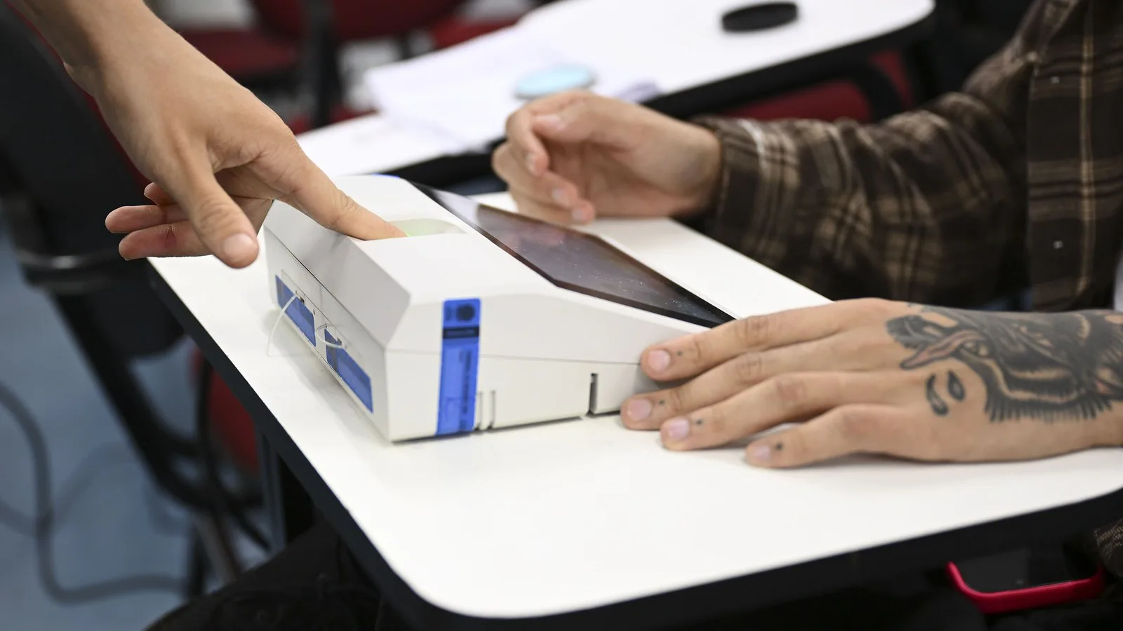 Eleitor encosta o dedo no leitor biométrico do terminal do mesário antes de votar, em Brasília, no 1º turno, em 4 de outubro de 2026