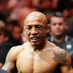 Lutador sem camisa, com tatuagem no ombro, participa de confronto de grappling cercado por espectadores em evento no Equador