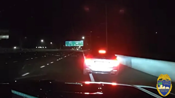 Imagem da câmera da viatura mostra, de madrugada, as lanternas de um carro à frente na rodovia