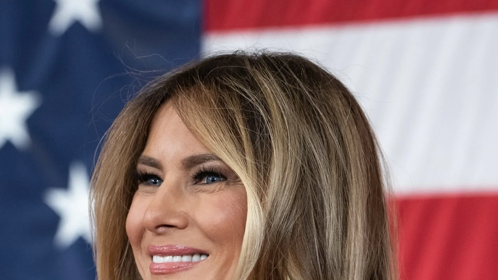 Melania Trump sorri diante de uma bandeira americana durante discurso para famílias de militares em Fort Bragg, na Carolina do Norte, em fevereiro de 2026 (imagem de arquivo)
