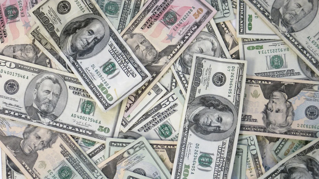 Notas de dólar de diferentes valores espalhadas, vistas de cima (imagem ilustrativa)