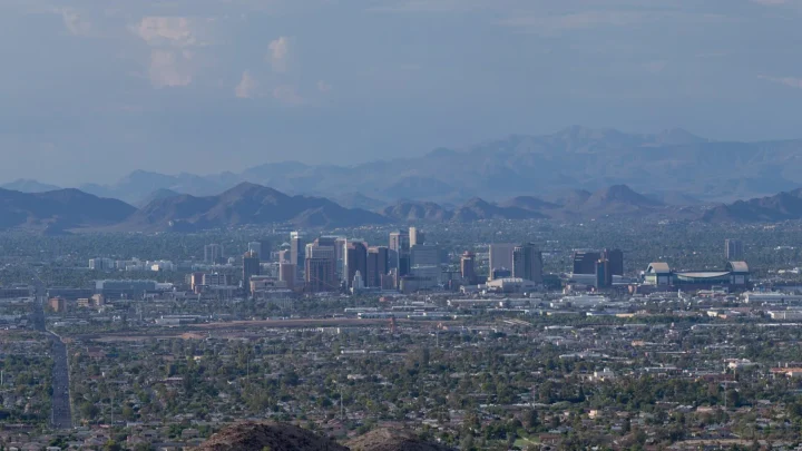 Foto de arquivo: prédios do centro de Phoenix, no Arizona, vistos de longe durante o dia, com montanhas ao fundo