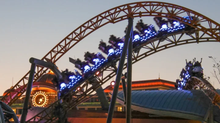 Foto de arquivo de abril de 2025, ao entardecer, de um trem da montanha-russa Stardust Racers com as luzes acesas no Epic Universe, em Orlando; a foto não mostra a fila nem o ventilador