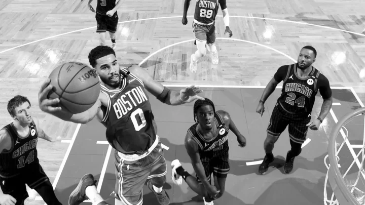 Jogador do Boston Celtics, de camisa 0, avança com a bola para a cesta sob marcação de jogadores do Chicago Bulls