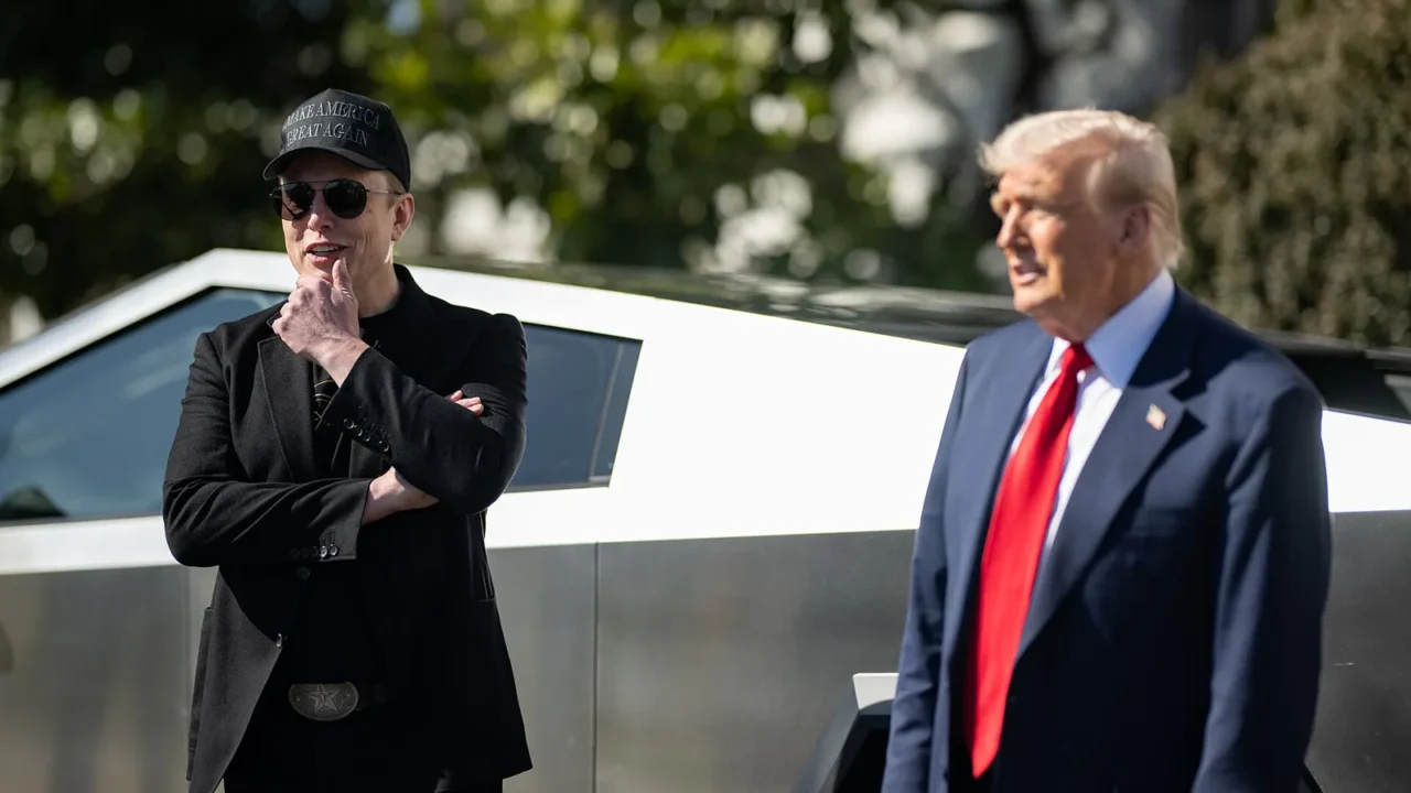 Elon Musk, de boné, óculos escuros e roupa preta, com a mão no queixo, ao lado de Donald Trump, de terno e gravata vermelha, diante de uma Cybertruck no gramado sul da Casa Branca, em março de 2025 (imagem de arquivo)