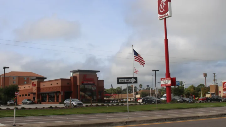 Foto de arquivo de uma unidade do Chick-fil-A em Lake City, na Flórida, com placa vermelha alta, bandeira dos EUA e estacionamento à beira da avenida