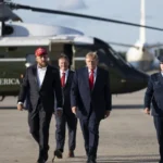 Jake Paul, de boné vermelho, caminha ao lado do presidente Donald Trump na Base Conjunta Andrews, em Maryland, antes de embarcar no Air Force One rumo a Youngstown, Ohio, em 12 de outubro de 2026