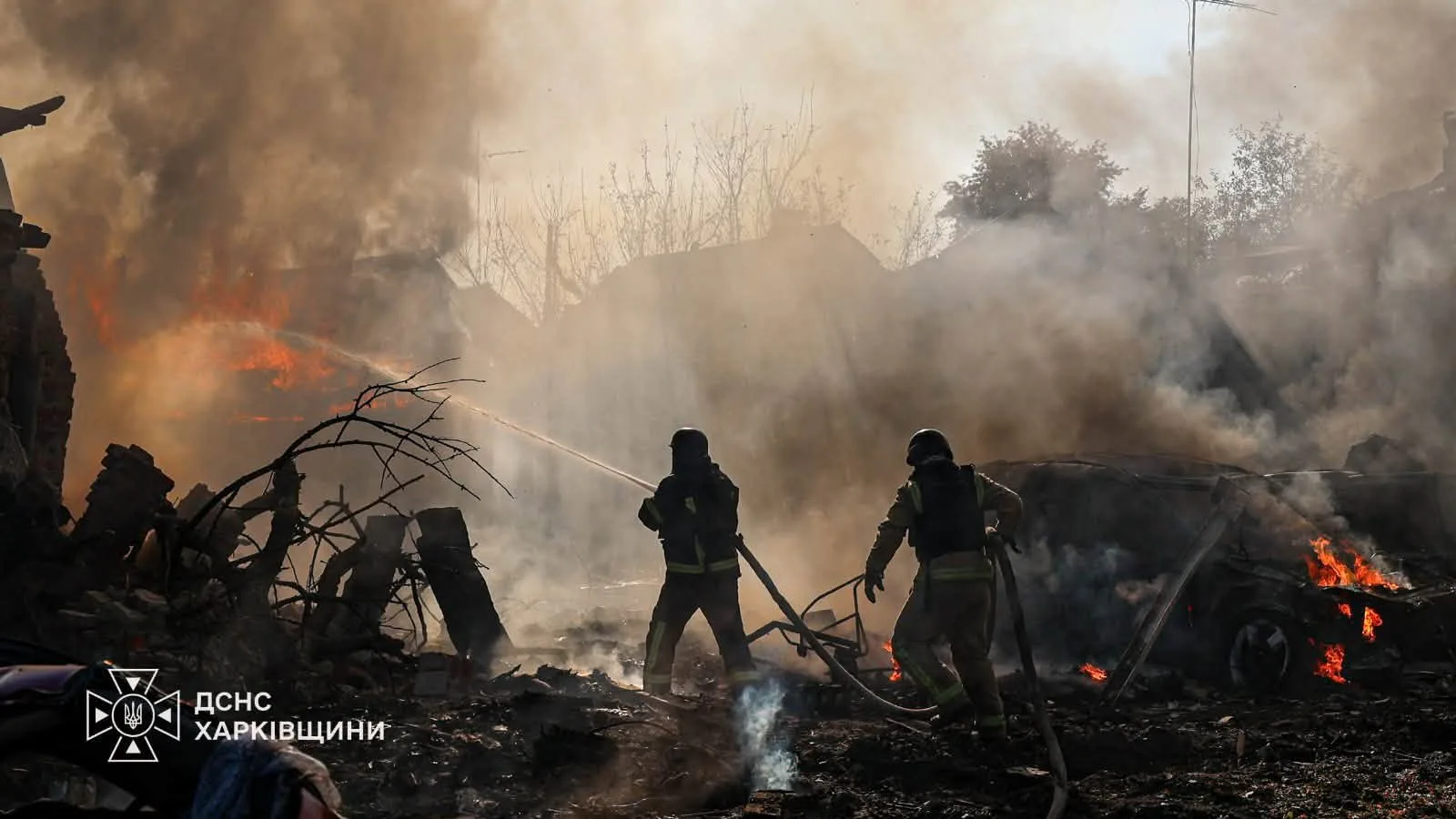 Bombeiros combatem incêndio entre escombros e um carro em chamas no distrito de Nemyshlianskyi, em Kharkiv, atingido por bomba guiada no mesmo 11 de outubro de 2026 (não é Pisochyn)