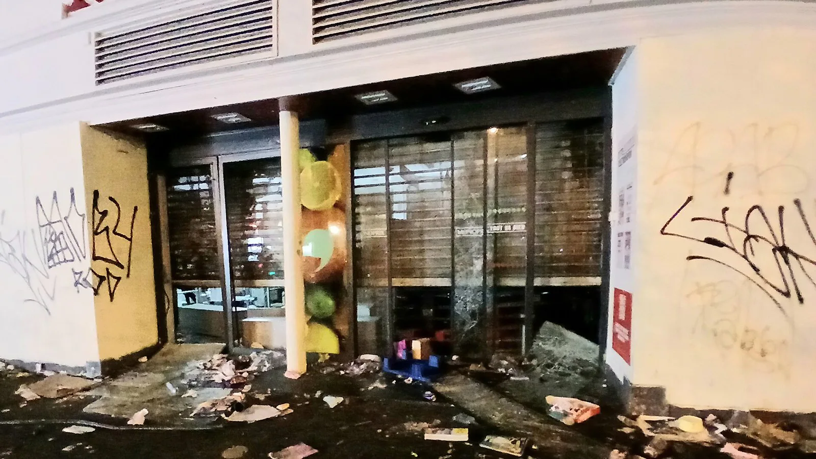 Supermercado com porta arrombada, pichações e mercadorias espalhadas no chão, no Faubourg Saint-Denis, em Paris, depois dos distúrbios de 17 de outubro de 2026
