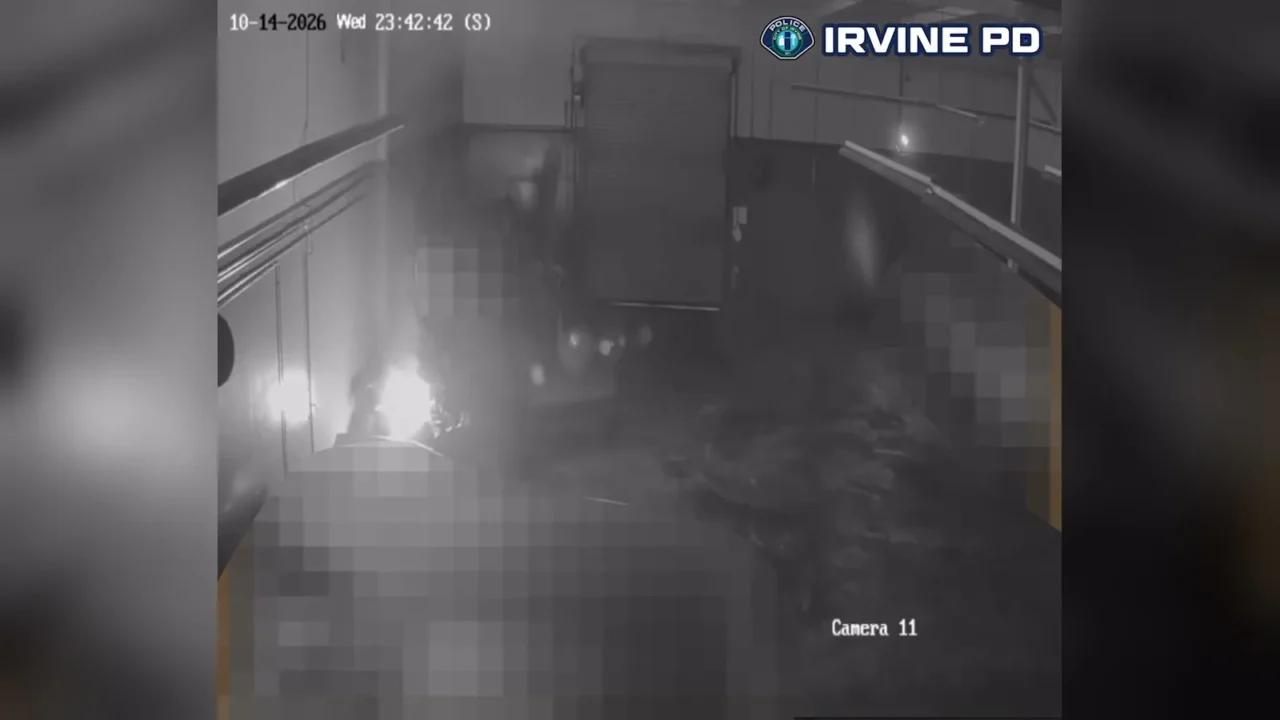 Câmera de segurança do pátio em Costa Mesa, às 23h42 de 14 de outubro de 2026 pelo carimbo da imagem, mostra o clarão do fogo no lado esquerdo do quadro e a fumaça se espalhando