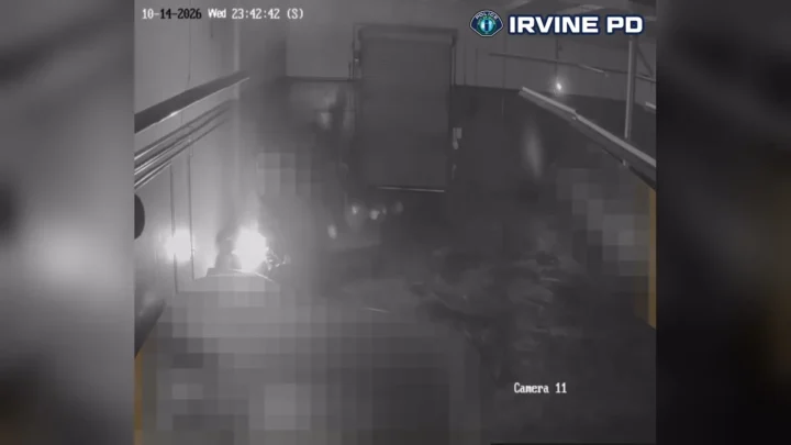 Câmera de segurança do pátio em Costa Mesa, às 23h42 de 14 de outubro de 2026 pelo carimbo da imagem, mostra o clarão do fogo no lado esquerdo do quadro e a fumaça se espalhando