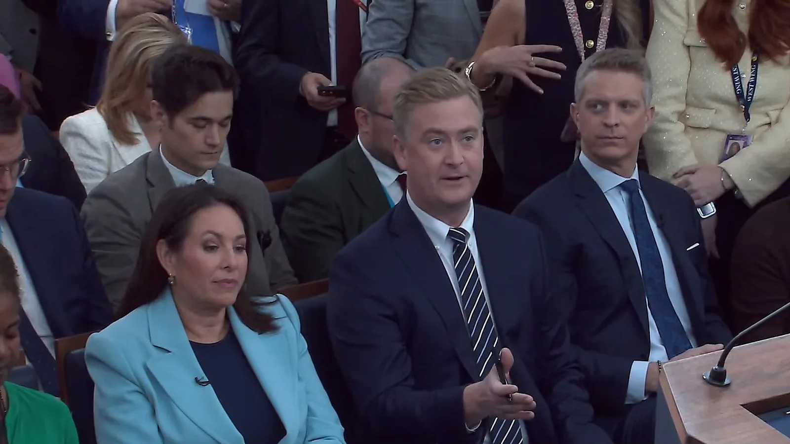 Jornalistas sentados na sala de imprensa James S. Brady acompanham a coletiva de Katie Zacharia