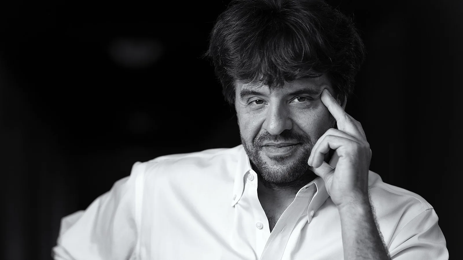 Karl Deisseroth, em preto e branco, com a mão apoiada na têmpora