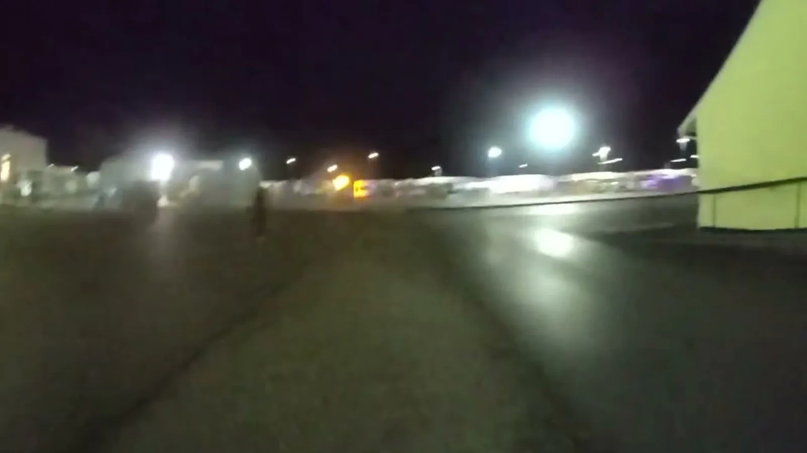 Câmera corporal de um agente em corrida mostra o motorista fugindo a pé por um estacionamento escuro