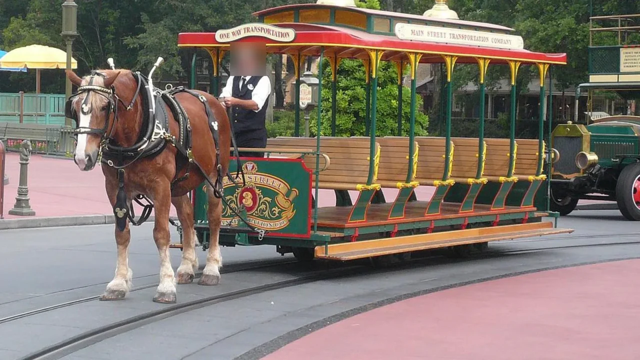 Foto de arquivo de um cavalo castanho de crina clara puxando o bonde de tração animal da Main Street, U.S.A., no Magic Kingdom, em Orlando, com o rosto do condutor desfocado