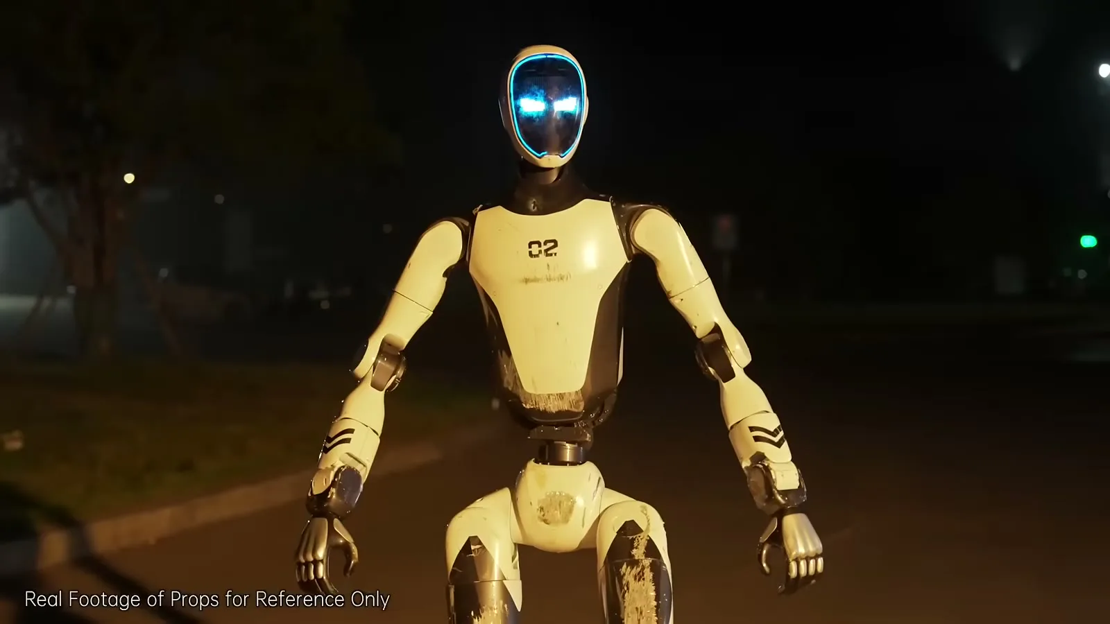 O robô H2-X de frente, com o rosto iluminado em azul, numa rua escura
