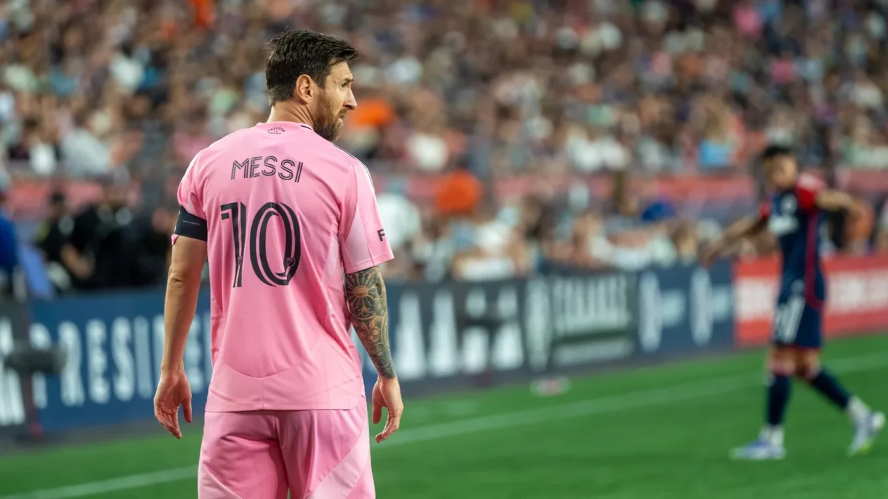 Lionel Messi, de costas com a camisa 10 rosa do Inter Miami, caminha no gramado durante jogo contra o New England Revolution em 2025