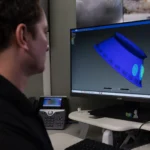 Stirling Allen, integrante do Grupo de Ambientes Dinâmicos do Escritório do Programa de Serviços de Lançamento da NASA, apresenta um software digital comercial no Centro Espacial Kennedy da NASA, na Flórida. O software realiza modelagem por elementos finitos para apoiar a análise de choque e