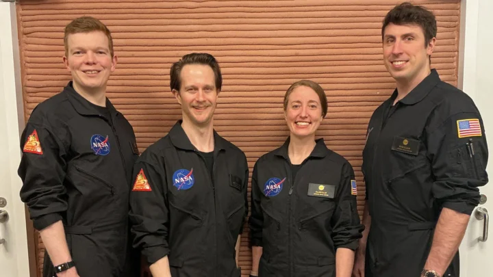 Os integrantes da tripulação da Missão 2 do CHAPEA (Crew Health and Performance Exploration Analog, Análogo de Exploração de Saúde e Desempenho da Tripulação) da NASA posam em seu espaço de trabalho depois de passarem um ano em seu habitat isolado e confinado no Centro Espacial Johnson da NASA, em