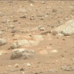 O rover Perseverance da NASA capturou esta imagem de alguns matacões de tom claro espalhados por uma encosta de uma região chamada “Lac de Charmes,” além da borda oeste da cratera Jezero. O Perseverance capturou a imagem usando sua câmera Mastcam-Z direita em 30 de agosto de 2026 (Sol 1965, ou dia