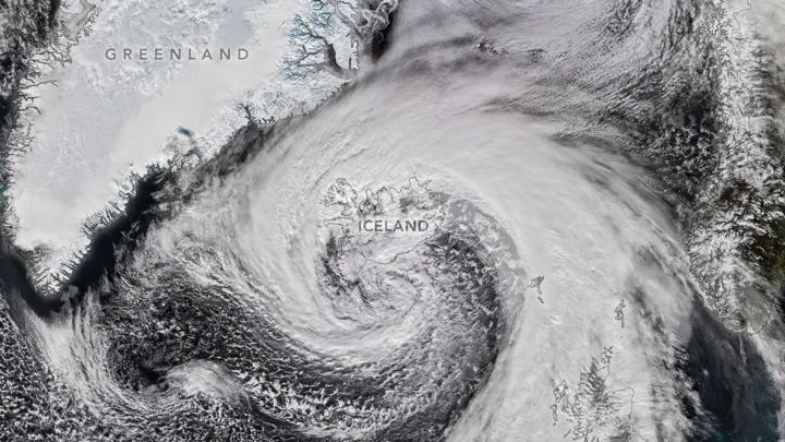 Nuvens de tempestade em espiral expansiva estão centradas perto do sul da Islândia. O sistema se estende pelo Atlântico Norte, da Groenlândia ao Reino Unido.