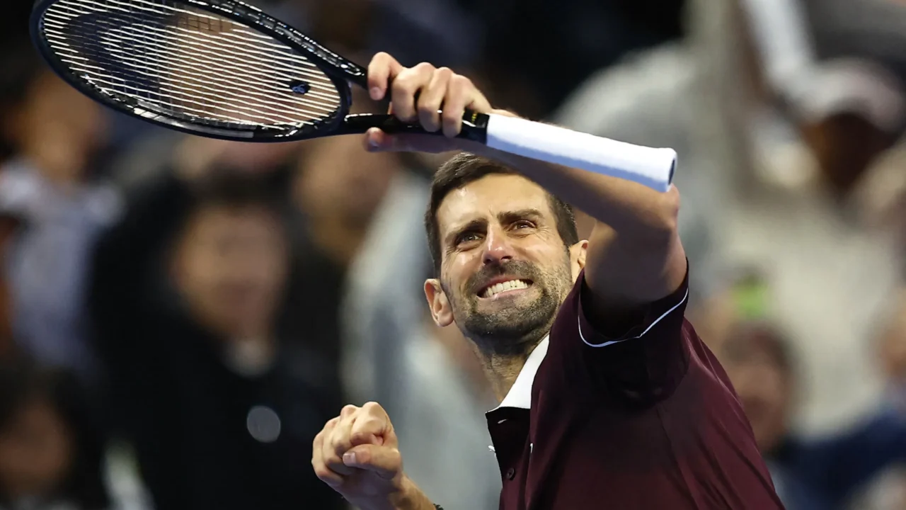 Tenista levanta a raquete durante partida do ATP 500 de Pequim, com público ao fundo