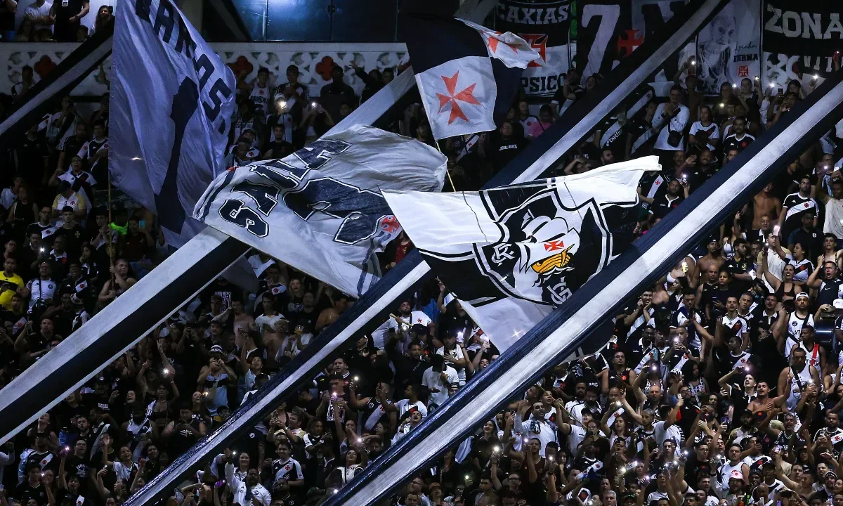 Torcedores do Vasco erguem bandeiras e celulares com lanternas acesas nas arquibancadas do estádio