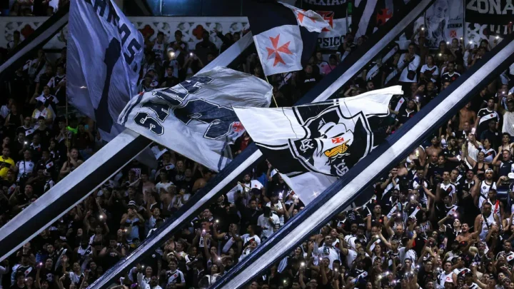 Torcedores do Vasco erguem bandeiras e celulares com lanternas acesas nas arquibancadas do estádio