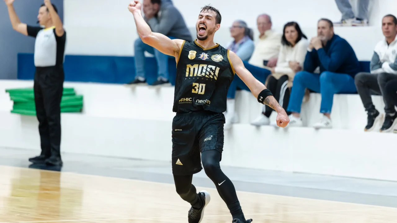 Jogador do Mogi comemora durante partida da Liga Sul-Americana de Basquete, com torcedores acompanhando nos arquivos da quadra