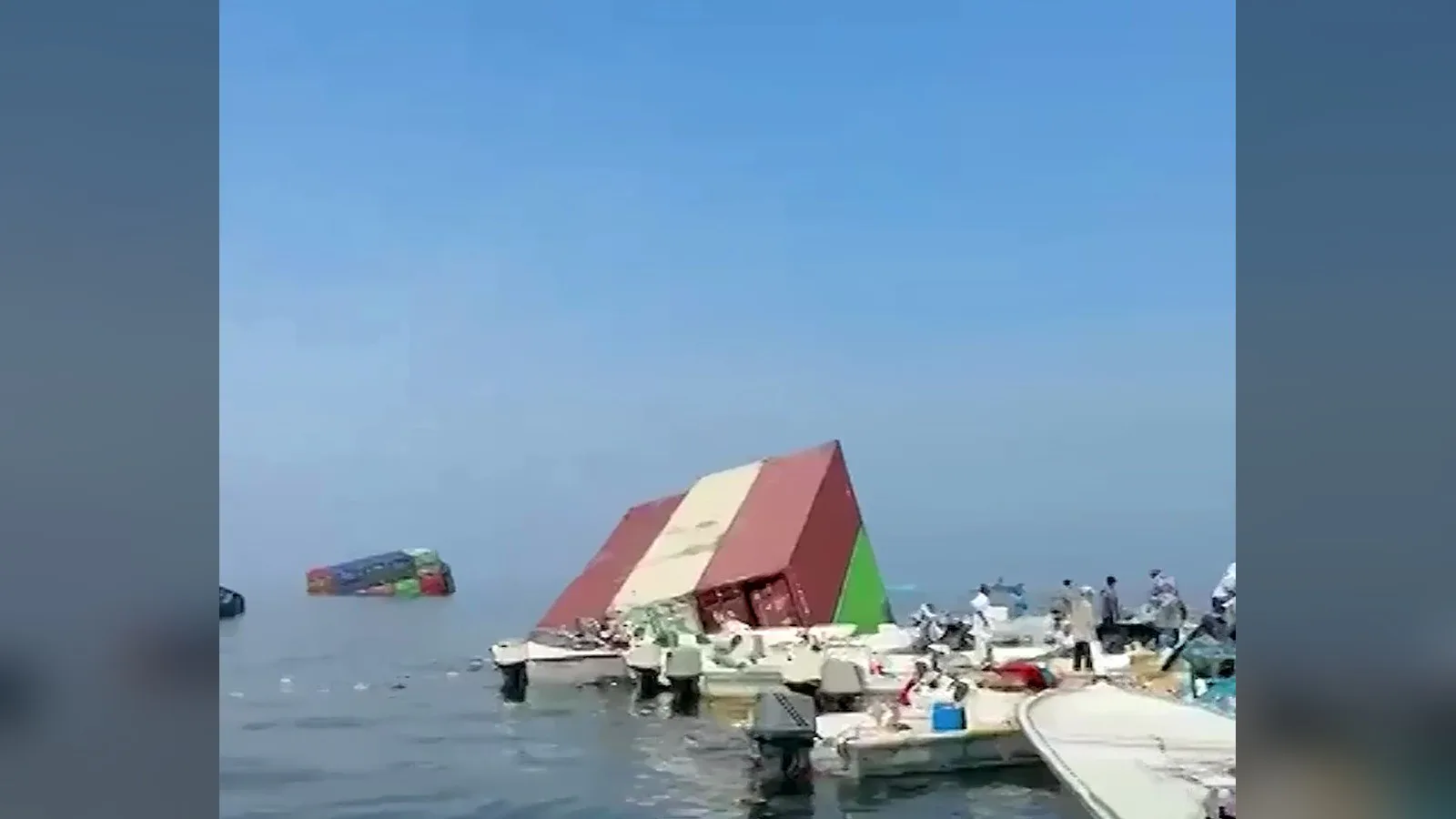 Contêiner tombado e meio submerso cercado por barcos de pescadores no Estreito de Ormuz