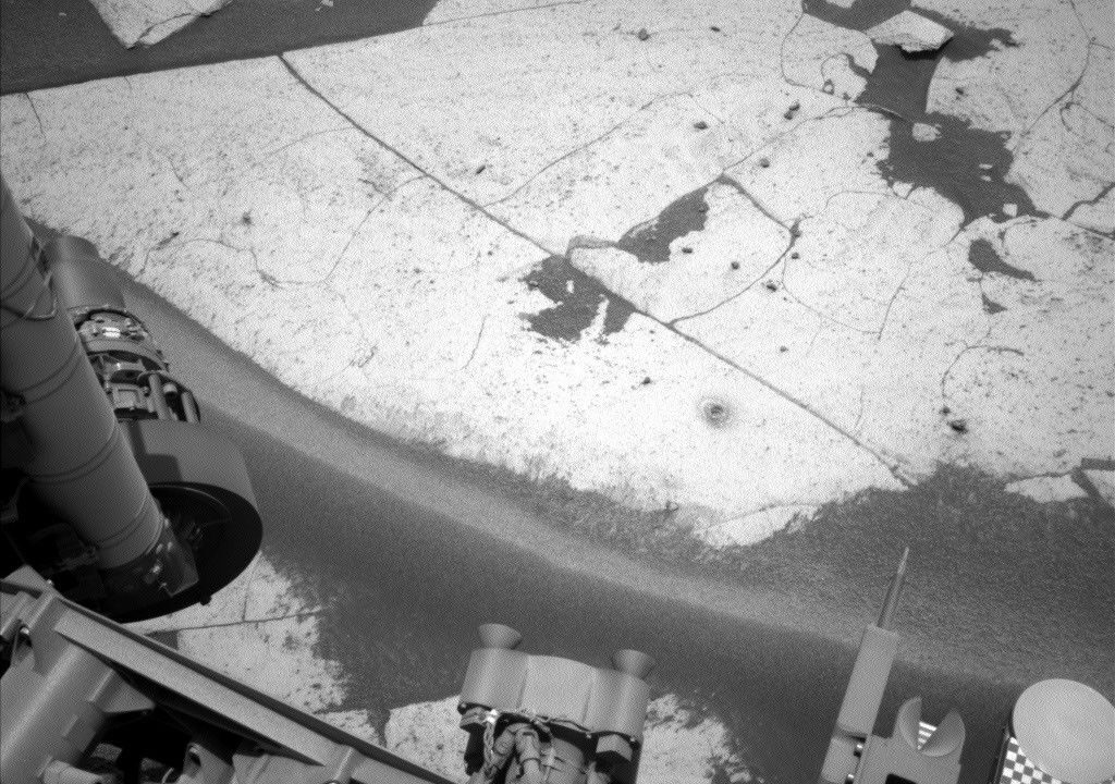 Imagem do furo de perfuração “Basque Lakes” e dos resíduos ao redor (o pequeno monte perto do canto inferior direito da rocha de base da área de trabalho). O rover Curiosity, da NASA, para Marte, obteve esta imagem usando sua Câmera de Navegação Esquerda (Navcam) em 24 de setembro de 2026, Sol