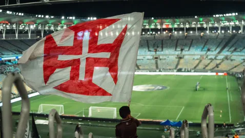 Torcedor do Vasco acena com bandeira do clube nas arquibancadas do estádio durante partida