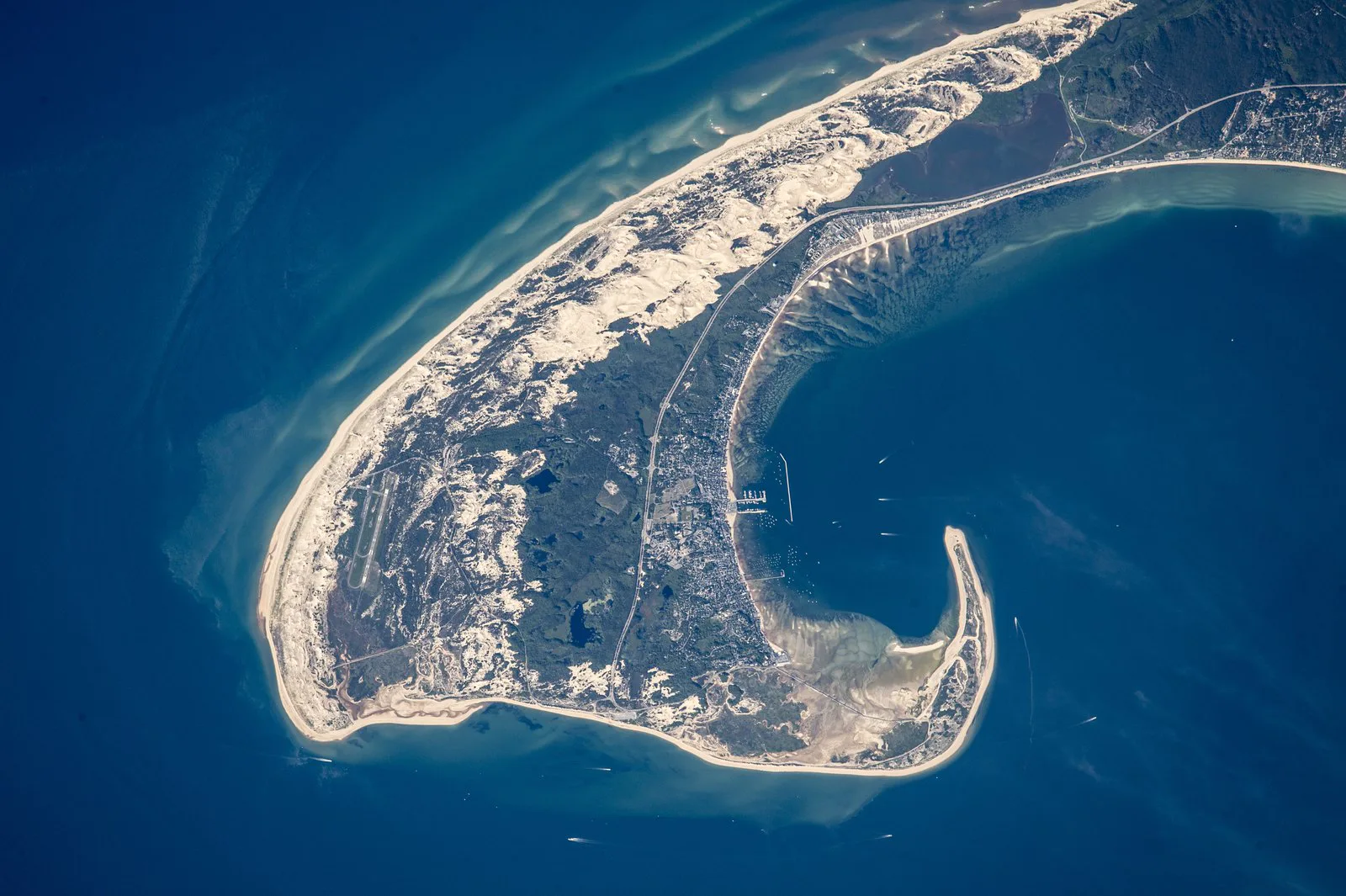 Ponta de Cape Cod, em Massachusetts, vista da Estação Espacial Internacional, com dunas, a área urbana e a curva de areia que fecha o porto