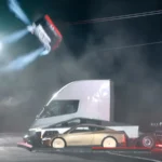 O Roadster da Tesla no ar, de lado, com jatos de ar comprimido, durante o salto sobre um caminhão elétrico na base da SpaceX em McGregor, no Texas