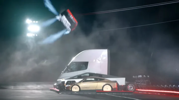 O Roadster da Tesla no ar, de lado, com jatos de ar comprimido, durante o salto sobre um caminhão elétrico na base da SpaceX em McGregor, no Texas