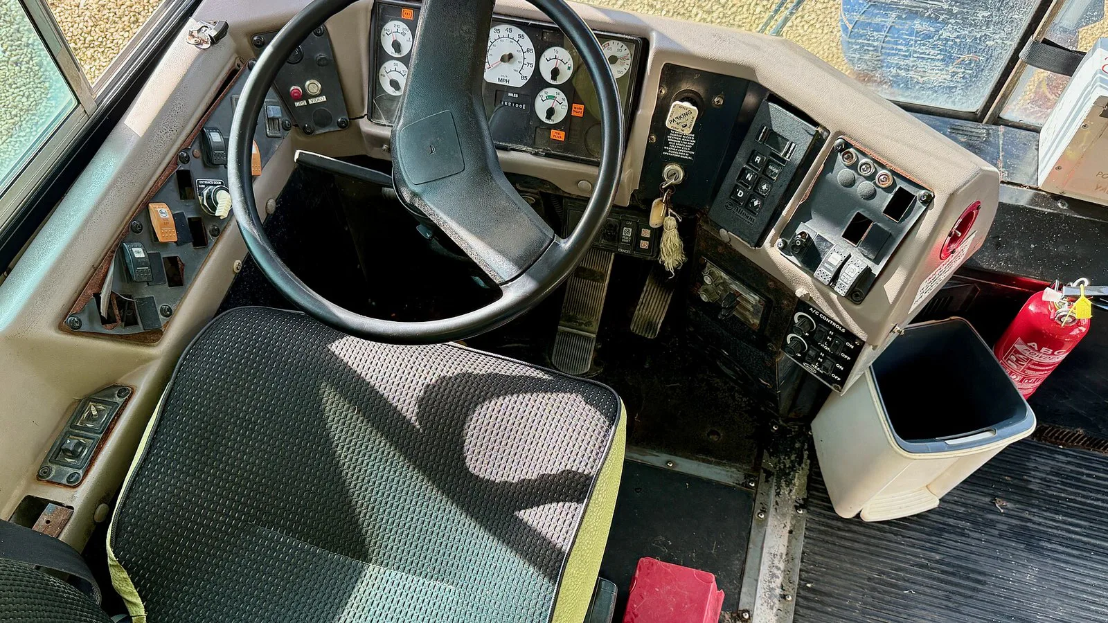 Posto do motorista de um ônibus escolar, com volante e painel, em dezembro de 2024 (imagem ilustrativa; não é o ônibus do caso)