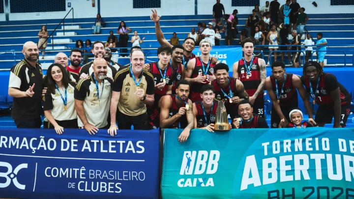 Jogadores e comissão técnica do Flamengo posam com medalhas e troféu dourado em quadra, atrás de faixas do NBB e do Torneio Abertura BH 2026