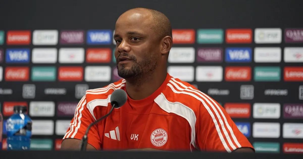 Treinador do Bayern de Munique, de camisa vermelha com o escudo do clube, fala em entrevista coletiva diante de painéis de patrocinadores