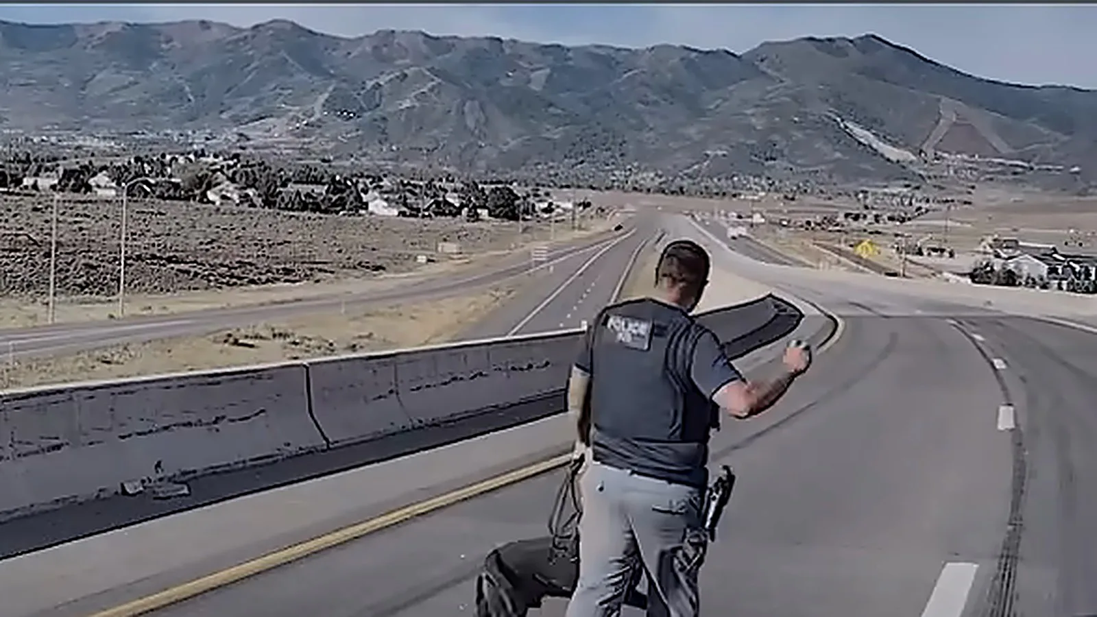 O policial faz sinal com a bola para Bruno começar a busca no viaduto que liga a US-40 à I-80, com as montanhas ao fundo