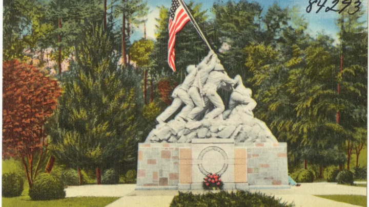 Cartão-postal antigo e colorido da estátua branca de Iwo Jima, com seis fuzileiros erguendo a bandeira americana, entre árvores na entrada da base de Quantico, na Virgínia (imagem de arquivo, anterior ao ataque)