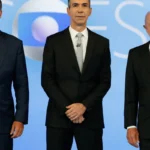 Flávio Bolsonaro, o mediador César Tralli e Lula, lado a lado no estúdio do debate da TV Globo, no Rio de Janeiro, em 23 de outubro de 2026