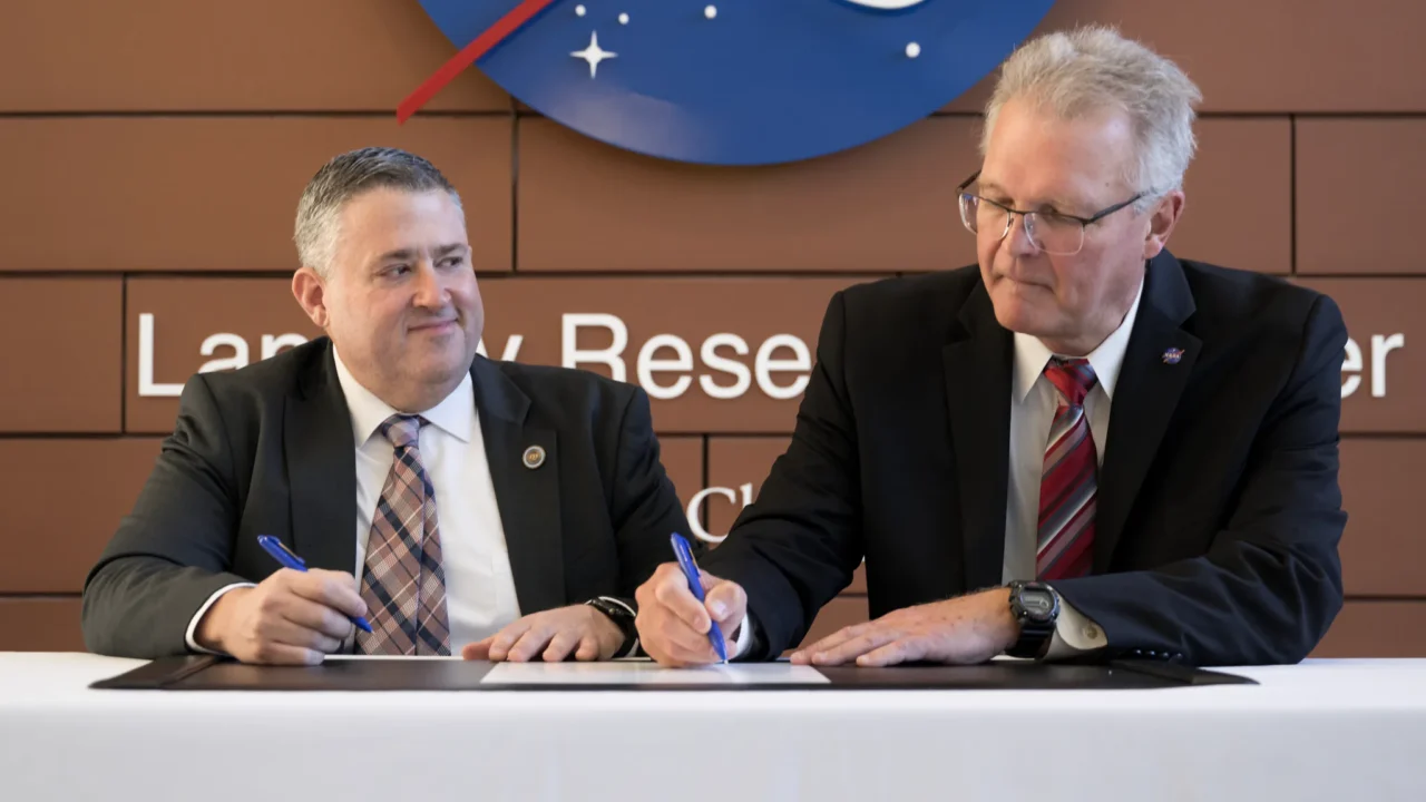 O diretor adjunto do NASA Langley, Allen Kilgore, e o diretor do Virginia Energy, Vince Maiden, assinam um novo Acordo da Lei Espacial (Space Act Agreement) durante a cerimônia que anunciou a parceria no NASA Langley, em Hampton, Virgínia. A NASA fornecerá informações de ciência atmosférica ao