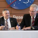 O diretor adjunto do NASA Langley, Allen Kilgore, e o diretor do Virginia Energy, Vince Maiden, assinam um novo Acordo da Lei Espacial (Space Act Agreement) durante a cerimônia que anunciou a parceria no NASA Langley, em Hampton, Virgínia. A NASA fornecerá informações de ciência atmosférica ao