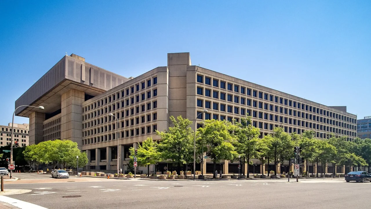 Edifício J. Edgar Hoover, sede do FBI, em Washington, com árvores na calçada e céu azul, em 2024 (imagem de arquivo)