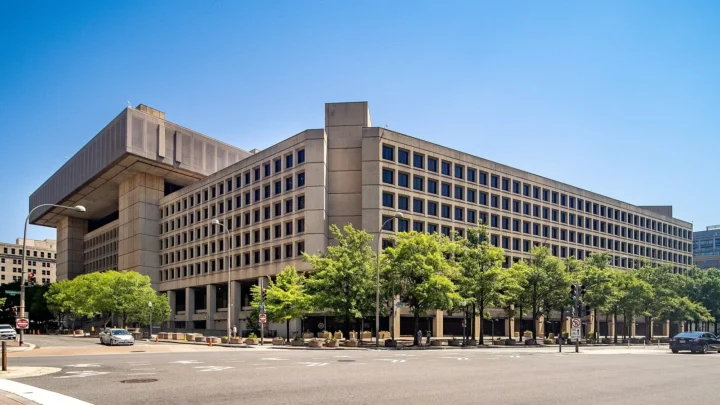 Edifício J. Edgar Hoover, sede do FBI, em Washington, com árvores na calçada e céu azul, em 2024 (imagem de arquivo)