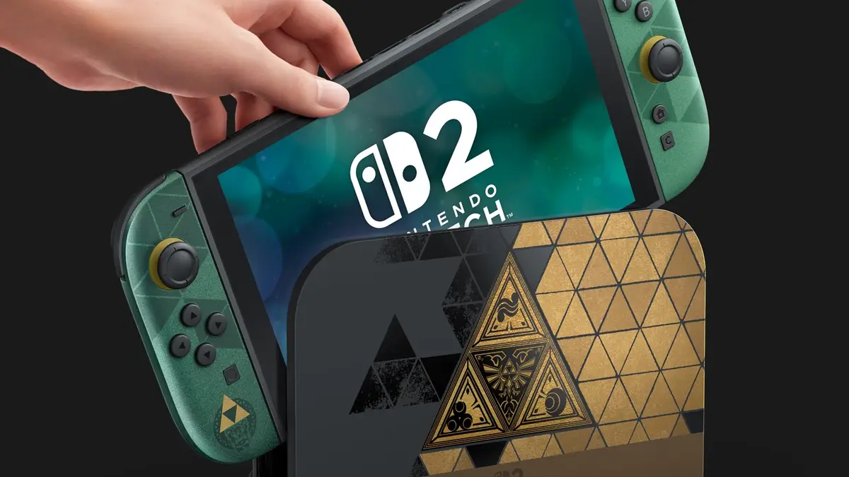 Mão segurando console Nintendo Switch 2 com controles laterais em tom verde e dock com design geométrico dourado e preto com símbolos de Zelda