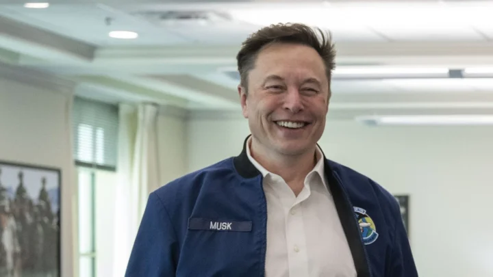 Elon Musk sorri, de jaqueta azul com o nome "Musk" bordado, em uma sala do Pentágono, na Virgínia, em março de 2025 (imagem de arquivo)