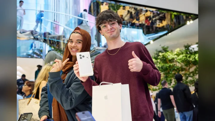 Clientes mostram a caixa do iPhone 18 Pro recém-comprado na loja da Apple da Quinta Avenida, em Nova York, no dia do lançamento
