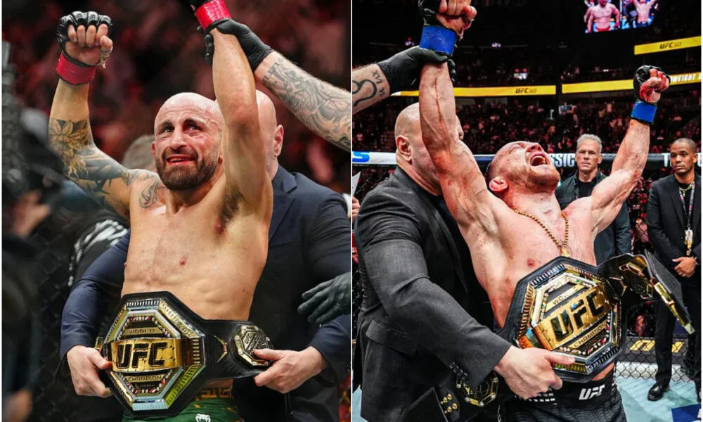 Dois lutadores de MMA, um de cabelo raspado e barba, outro de cabelo escuro e cordão no pescoço, erguem os braços e seguram cinturões dourados do UFC dentro do octógono
