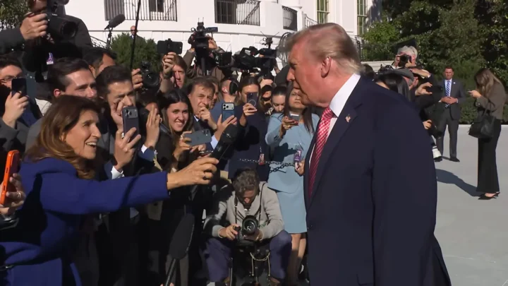 Donald Trump fala com jornalistas que estendem celulares e microfones no gramado da Casa Branca, em 19 de outubro de 2026